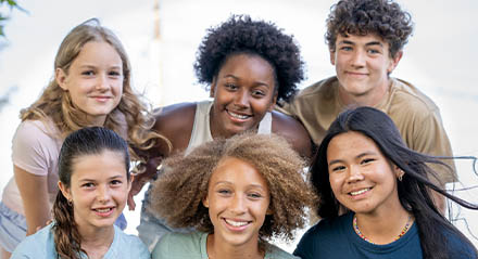 A diverse set of youths hugged in a group