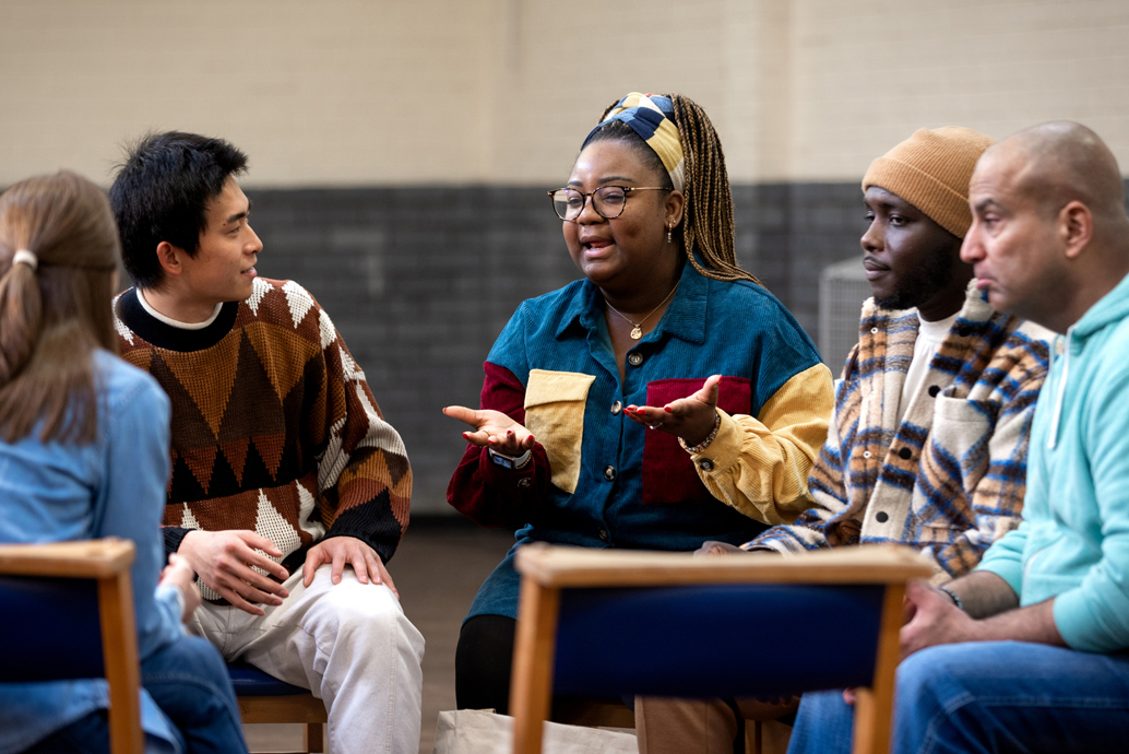 diverse group of people sitting around a table and talking