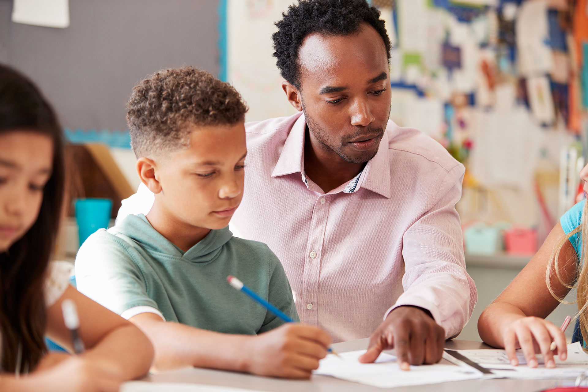 Black Male teacher helping student with work