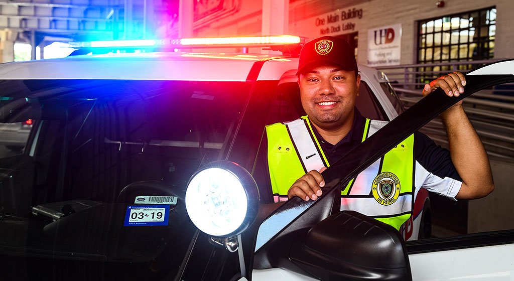 Public officer, next to a police vehicle Public officer, next to a police vehicle.