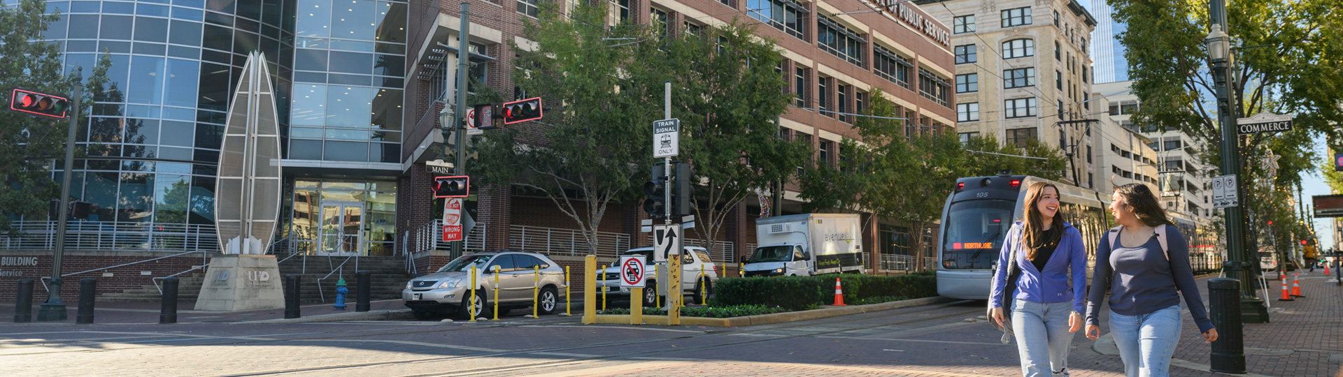 UHD students walking and chatting with the CPS building in the background