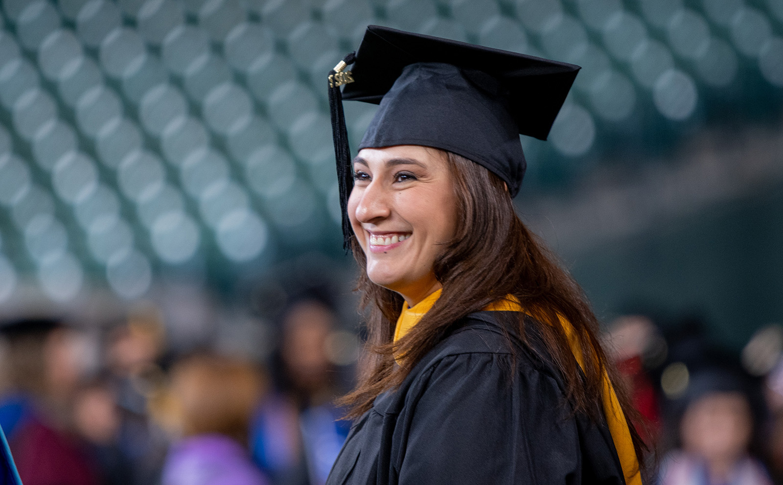 UHD graduate in cap and gown at graduation ceremony
