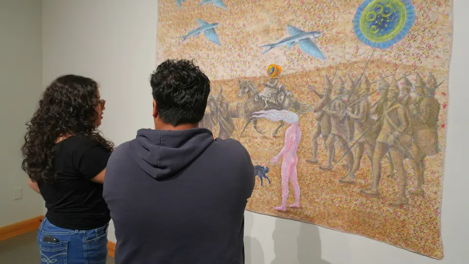 Man and woman looking at a painting on the wall