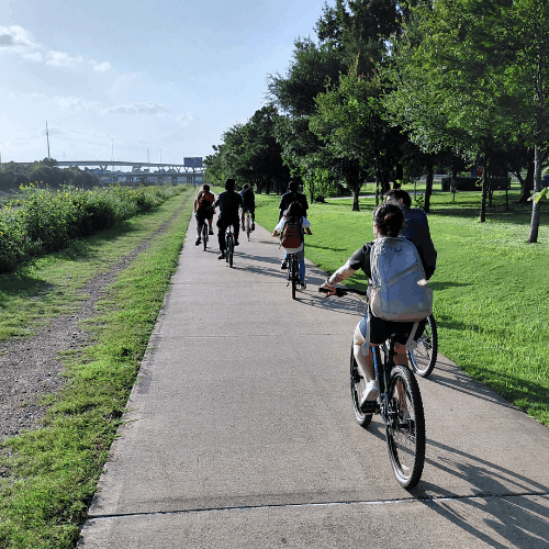students in university of houston downtown's bke club ride on a trail aside the bayou