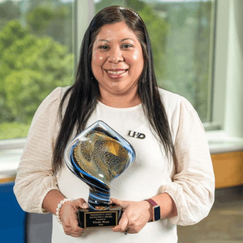 Gladis Moya holds the President's Staff Excellence Award at the University of Houston Downtown