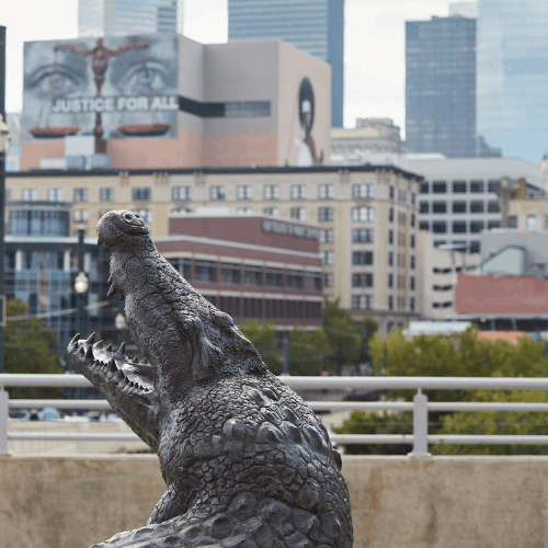 A gator statue on the University of Houston Downtown campus overloooking the Downtown Houston skyline. 