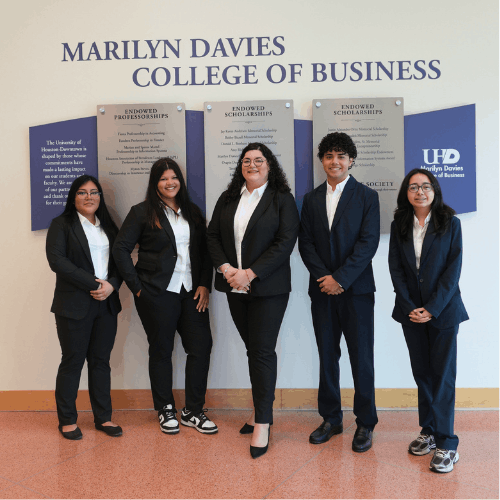 Five Ted Bauer Undergraduate Business Scholars wear professional suits from The C. T. Bauer Foundation in the lobby of the Marilyn Davies College of Business at the University of Houston-Downtown in Downtown Houston