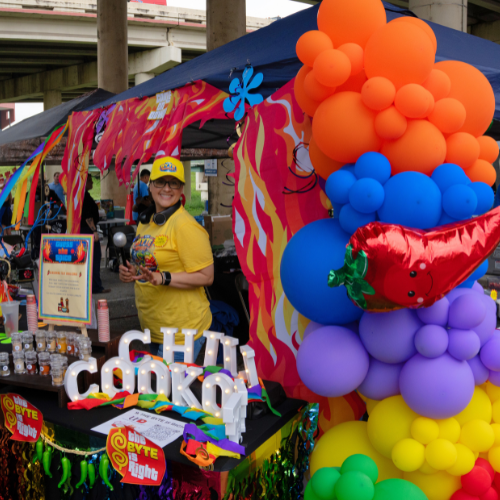 A staff member at a decorated tent for the annual chili cookoff at the university of houston-downtown